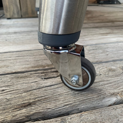 Grijze prototype wielkit met chromen wielen en zwarte rubberen banden onder een Everdure barbecue poot.